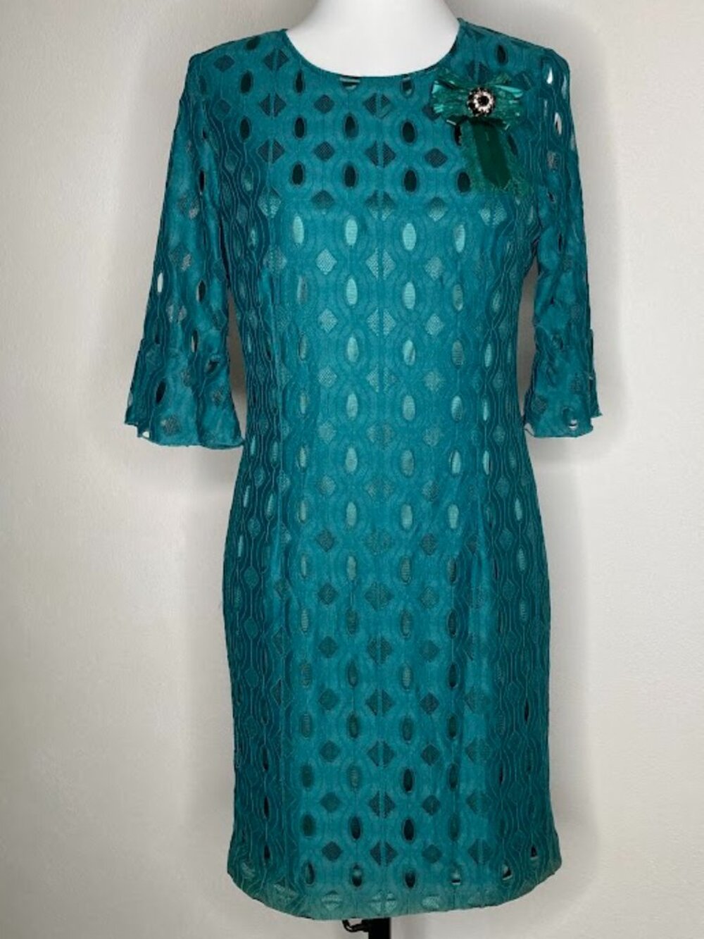 #70715 straight-cut dress in openwork lace features an elegant deep green hue.